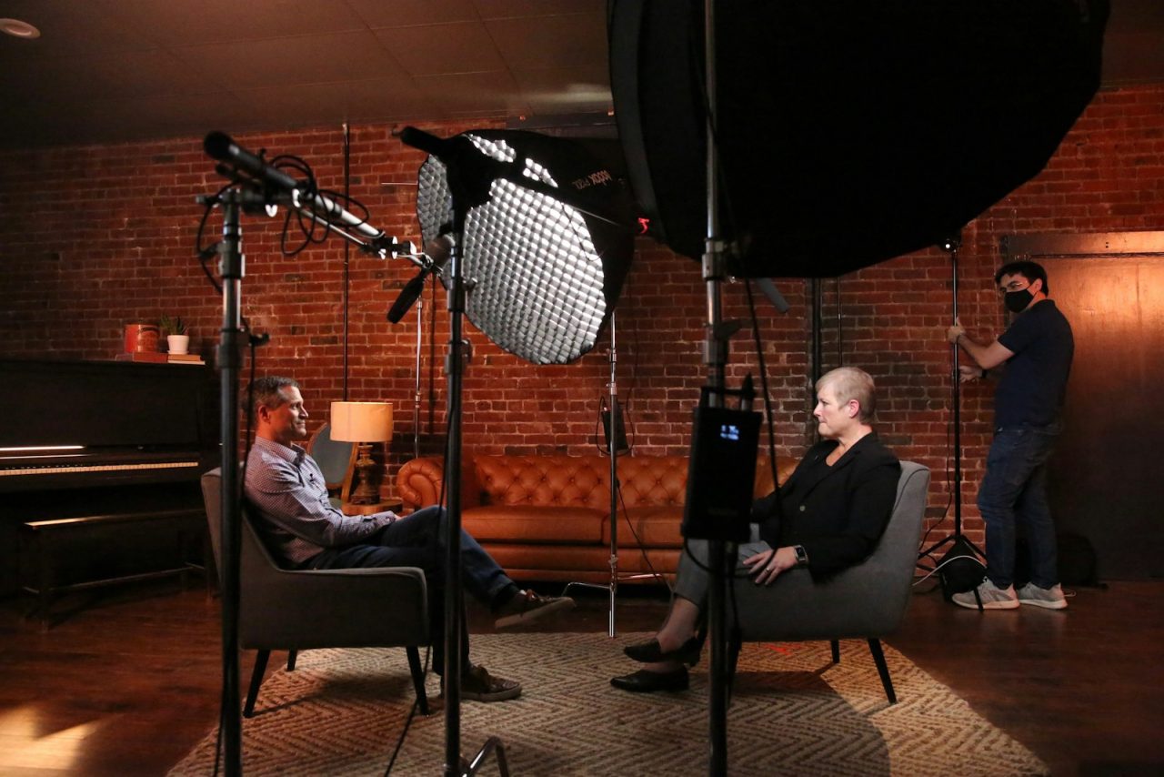 Video marketing: a man and a woman seated in front of a camera filming a business interview