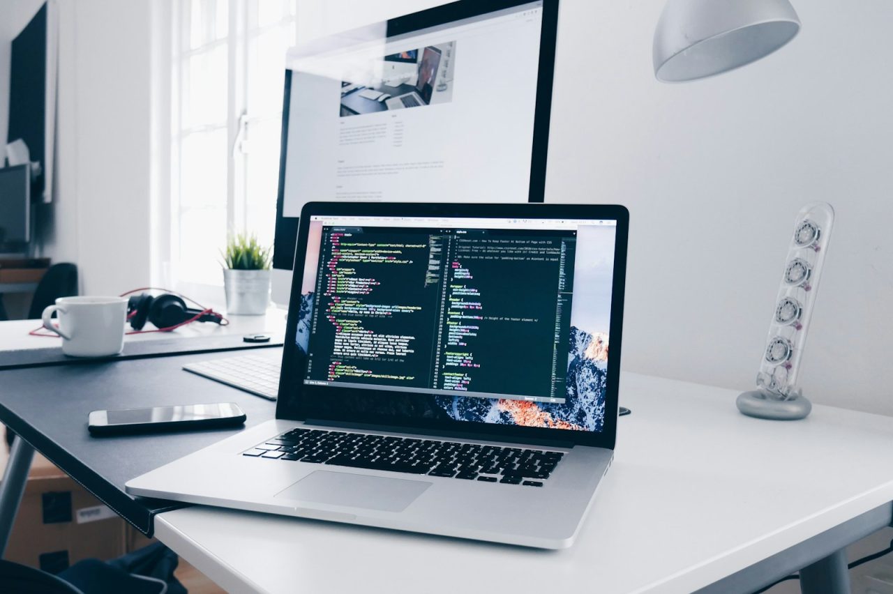 Website management: a laptop showing website code on a busy desk